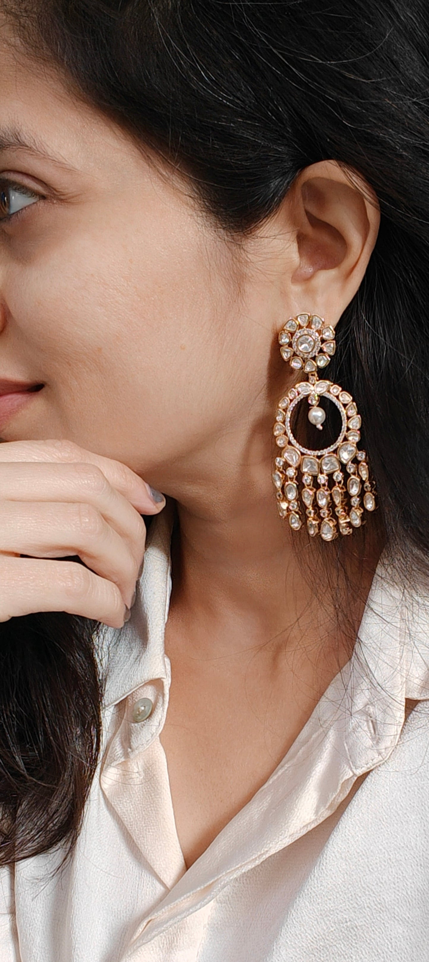 Close-up of a woman wearing elegant earrings with a neutral background