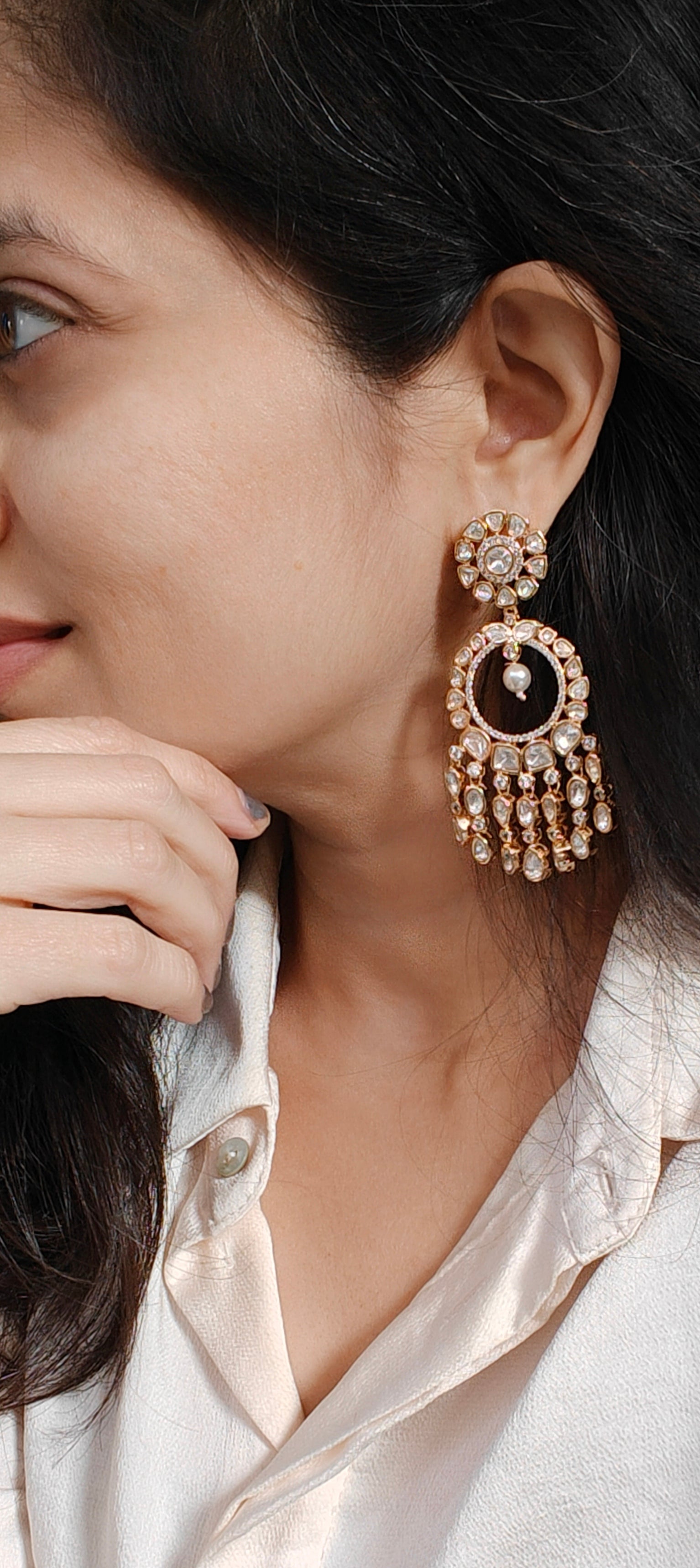 Close-up of a woman wearing elegant earrings with a neutral background